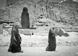 Due donne passano davanti all'enorme cavità dove si trovava uno degli antichi Buddha di Bamiyan. Foto del sergente Ken Scar, 2012. Fonte: flickr.com/photos/dvids/7408738172