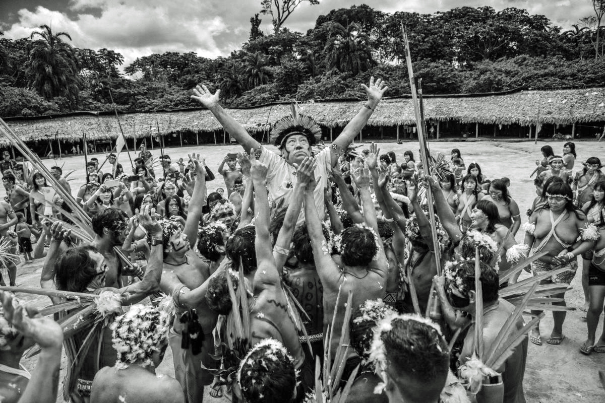 Davi Kopenawa Yanomami viene sollevato nel centro del villaggio Xihopi, Terra indigena Yanomami, nello Stato di Amazonas. Foto di Christian Braga/ISA. Fonte: https://www.socioambiental.org
